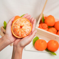 Cut part of orange fruit in human hands