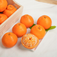 Ripe juicy orange tangerine whole in peel and slices isolated on white background with copy space, flat lay clipping path
