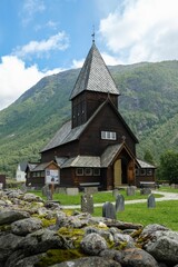 Fototapeta na wymiar Vertical shot of the historic Roldal Stave church near the mountains in Norway