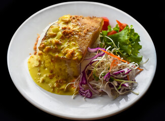 Grilled basa fish with rice and salad on black background
