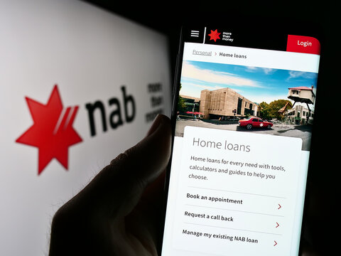 Stuttgart, Germany - 03-17-2023: Person holding cellphone with website of company National Australia Bank Limited (NAB) on screen with logo. Focus on center of phone display.