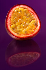 Maracuja Frucht mit Spiegelung auf violettem Fond