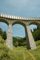 Vertical low-angle shot of the Spiral viaduct and its surrounding greenery in Brusio, Switzerland