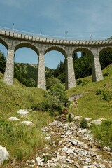 Fototapeta na wymiar Vertical low-angle shot of the Spiral viaduct and its surrounding greenery in Brusio, Switzerland