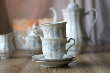 Vintage white tea set with pale blue flowers. Selective focus.