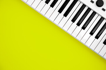 Fototapeta na wymiar Midi keyboard on green background, flat lay, musical creativity concept, copy space.