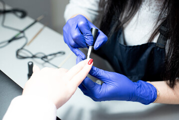 Professsional nails care in beauty salon.Manicurist paints fingernails. Process of making nail design with art. 