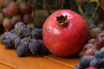 Closeup of a ripe juicy red Armenian pomegranate and grapes