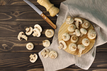 fresh large fragrant champignon mushrooms in a dark kitchen next to a knife and pepper shaker. for labels splash screens menu banners shop signs