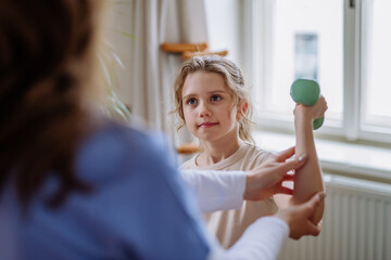 Little girl doing exercise with a nurse.