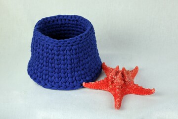 Little blue crochet bowl and a starfish toy laying on the table