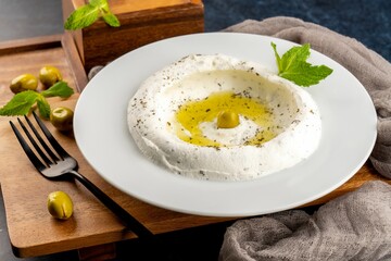 Closeup shot of Greek yogurt Labneh with dry mint, cold appetizer on a white plate