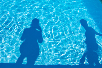 deux ombres sur l'eau d'une piscine © veroniquepeyle
