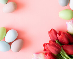 Easter eggs and tulips on light green background