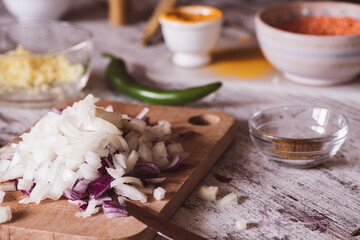 Fototapeta na wymiar Chopped onion on a wooden cutter on a kitchen table