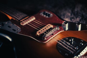Fototapeta na wymiar Closeup shot of a modern, brown electric guitar on the ground