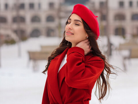 beautiful girl in a red coat and red beret in winter