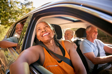 Group Of Senior Friends Enjoying Day Trip Out Driving In Car Together