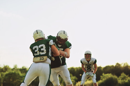 American football players practicing tackling