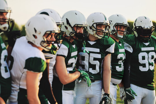 Smiling American football team standing on sports field