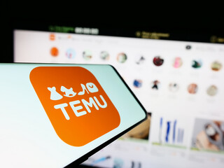 Stuttgart, Germany - 03-17-2023: Mobile phone with logo of American online shop company Temu on screen in front of business website. Focus on center of phone display.
