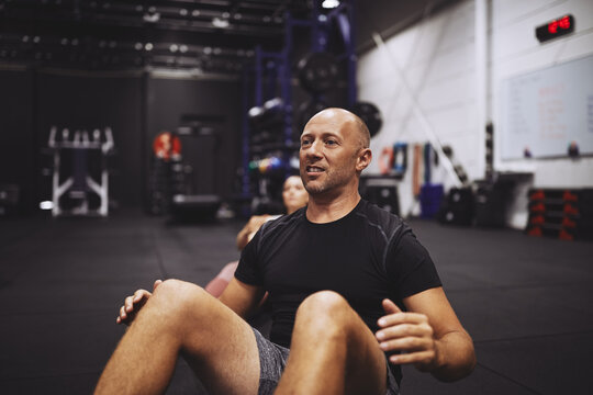 Mature man doing crunches during an exercise class