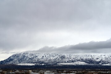 Scenic shot of a mountain range covered in snow under the clouded sky