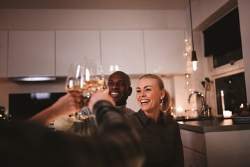 Couple laughing while toasting friends during an candlelit dinner party