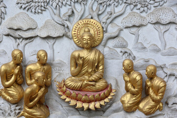 Relief depicting a scene of the Buddha's life in Wat Chai Mongkhon, Chiang Mai. Buddha surrounded by disciples. Thailand
