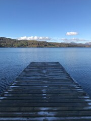 Obraz premium Lake view with a wooden jetty and a blue sky background. Lake Windermere England. 