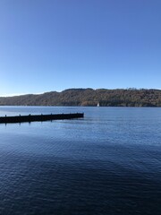 Obraz premium Lake view with a wooden jetty and a blue sky background. Lake Windermere England. 