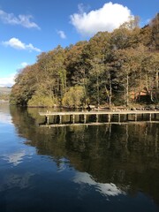 Obraz premium Lake view with a wooden jetty and a blue sky background. Lake Windermere England. 