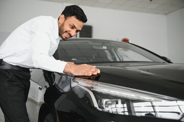 Fototapeta na wymiar happy indian man buy new biodiesel eco automobile in lux showroom.