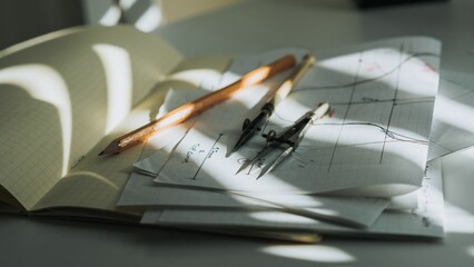 Vintage drawing tools laying on a stack of paper