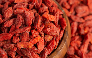 A Bowl of Red Dehydrated Goji Berries in a Wooden Bowl in the Kitchen