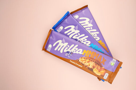 Chocolate brand Milka with Oreo flavor and caramel on a soft pink background.