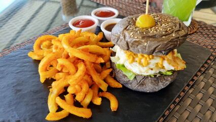 Fresh delicious burger and French fries with sauces.