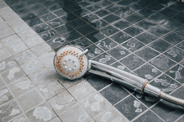 Silver shower head with limescales. Shower damaged from water scale.