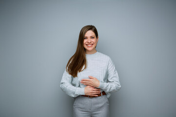 Happy woman holding hands on stomach isolated portrait.