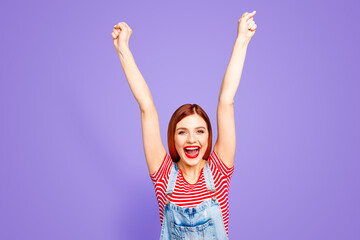 Fototapeta na wymiar Portrait of nice vivid girlish red straight-haired glad happy smiling young girl with opened mouth, raising hands up, isolated over blue background