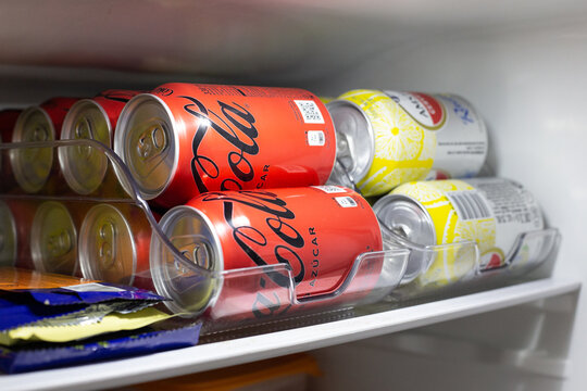 cans of sugar-free Coca Cola soft drinks in a home refrigerator. Consumption of sugar-free drinks