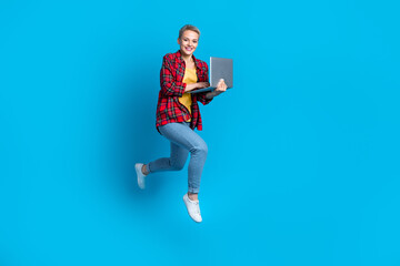 Full length size photo cadre of young perspective programmer junior coder woman student hold netbook jumping isolated on blue color background
