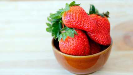fresh strawberries in a  ceramic bowl on wooden background with space for text, healthy strawberry fruits, summer fruit