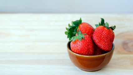 fresh strawberries in a  ceramic bowl on wooden background with space for text, healthy strawberry fruits, summer fruit