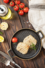 Restaurant food. Seafood. Rustic style. Cooked juicy tuna steak  with spices, tomatoes and rosemary on a stone plate.