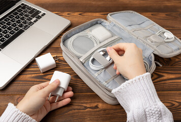 Using a holder for storing and transporting wires. Wires of modern electronic equipment in a convenient storage bag. Preparing for a business trip or vacation. Packing method and technological tools.
