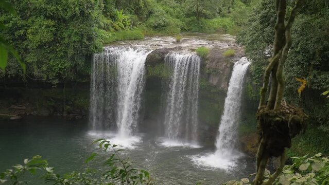 Spectacular waterfall between the trees in the rainforest in Laos
