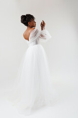 Naklejka premium Beautiful African American woman posing in a wedding dress. Fashion model in a white dress.
