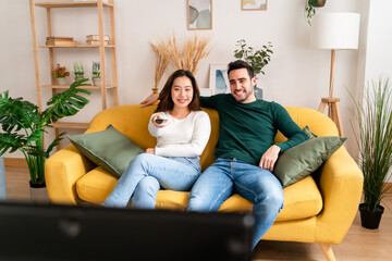 Happy couple hugging and watching TV in room