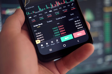 Fototapeta na wymiar Businessman trader using smartphone checking stock exchange. Man using mobile phone with investing application. Stock market investment and trading cryptocurrency on app in hand. Online business data
